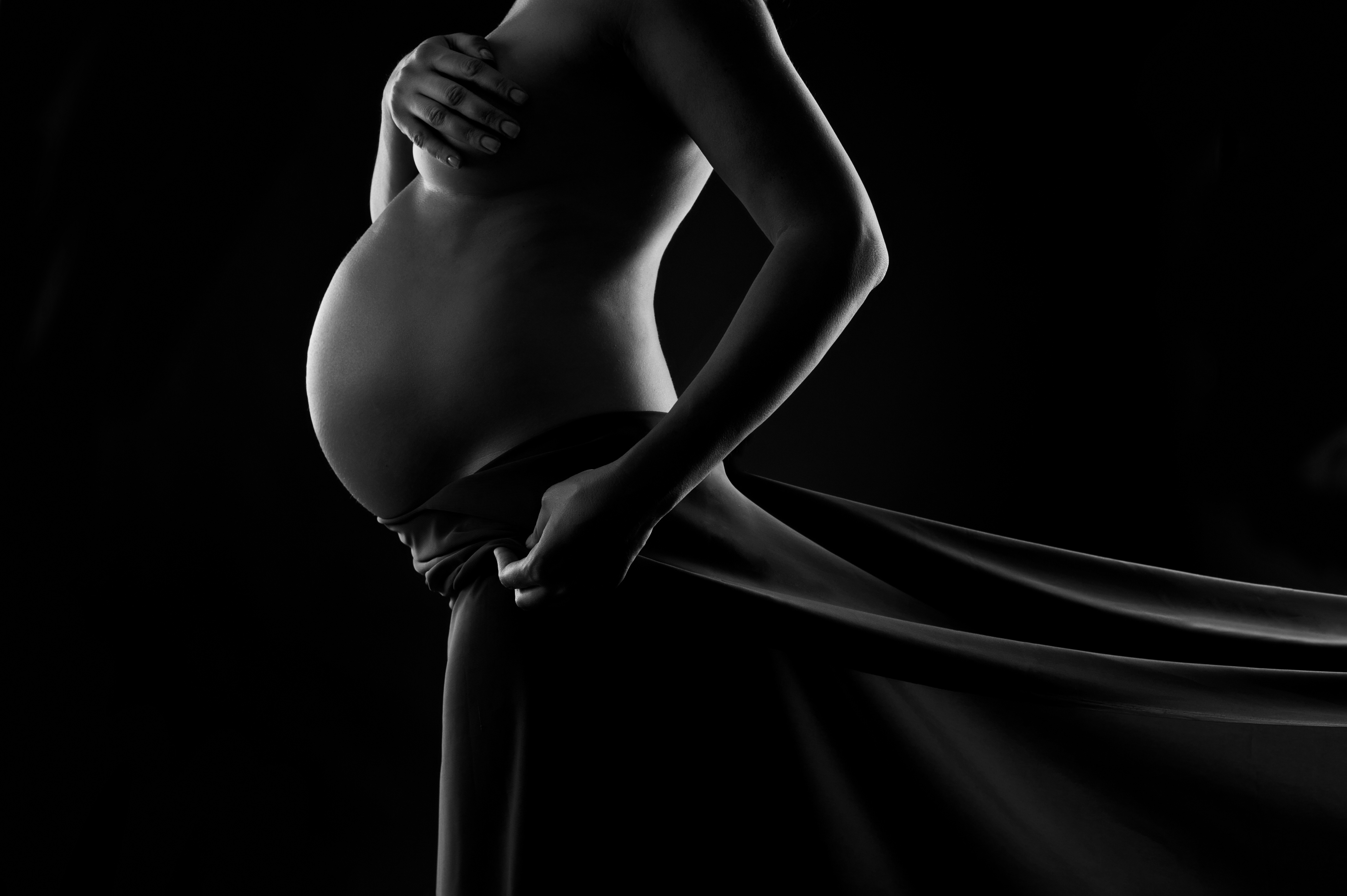 Беременная на черном фоне